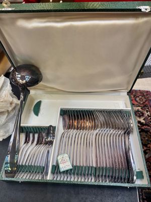 a suitcase with silverware inside of it on a table