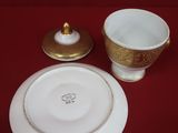 a white plate with a gold rim and a white bowl with a gold rim