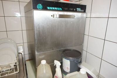 une photo d'une cuisine avec un lave-vaisselle et une poubelle