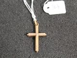 une croix en or suspendue à un cordon blanc, avec une étiquette de prix