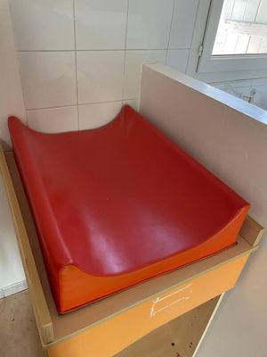 a red seat that is on top of a wooden table