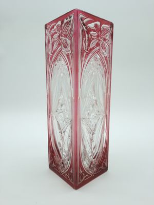 une photo d'un vase en verre rouge posé sur une table blanche