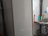 a refrigerator in the corner of a kitchen with a sink