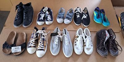 Plusieurs paires de chaussures de tennis sont alignées sur une boîte en carton