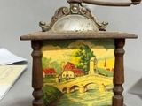 a small clock with a painting on it sitting on a table
