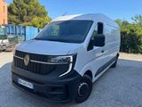 une camionnette blanche garée sur un parking à côté d'un bâtiment