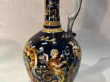 a blue and gold vase sitting on a white surface