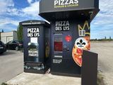 a small pizza kiosk with a large pizza on it