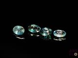 three blue topazte gems sitting on a black surface