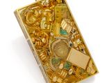 une boîte de bijoux en or posée sur une surface blanche
