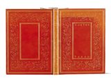 un vieux livre à la couverture rouge et à la bordure dorée
