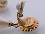a close up of a pair of earrings with pearls on them
