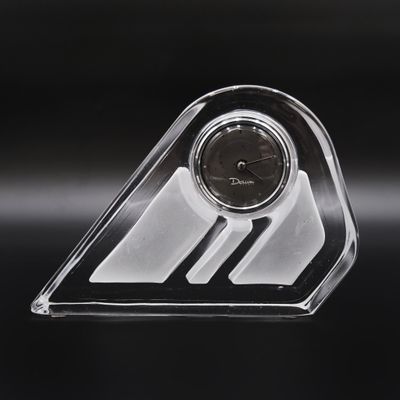 une horloge transparente posée sur une table