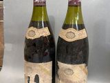 two bottles of wine sitting next to each other on a table