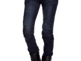 une femme en t-shirt noir et en jean, posant les bras croisés