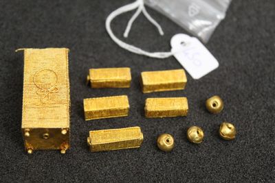 some gold pieces and a bag on a table