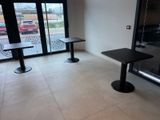 two tables and a bench in the corner of a room