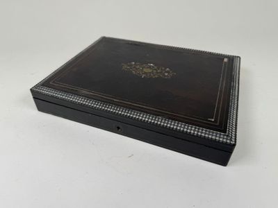 a black box with a gold emblem on it sitting on a white surface