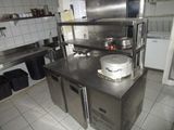 a large stainless steel counter in a kitchen with pots and pans on it