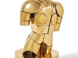 gold iron man statue on a white surface with a white background