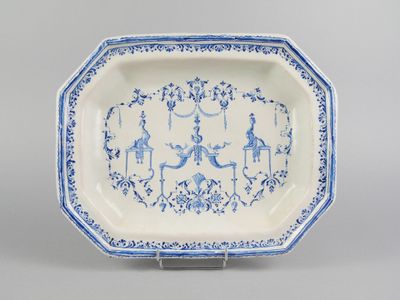 une assiette bleue et blanche ornée de motifs représentant des personnages