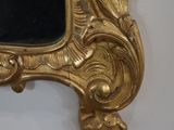 a gold frame with a mirror on it on the wall