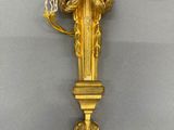 a gold clock with a bird on it ' s face hanging on a wall