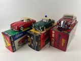 plusieurs petites voitures posées sur des cartons, sur une surface blanche