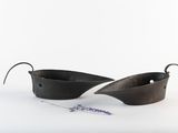 two black pots with handles on a white surface