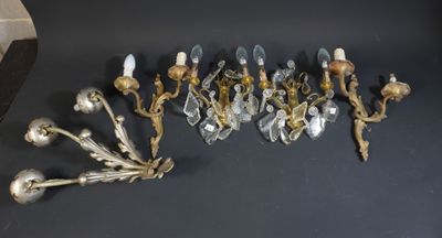 plusieurs appliques murales anciennes en laiton et cristal sur un fond noir