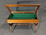an antique wooden display case with green velvet inside