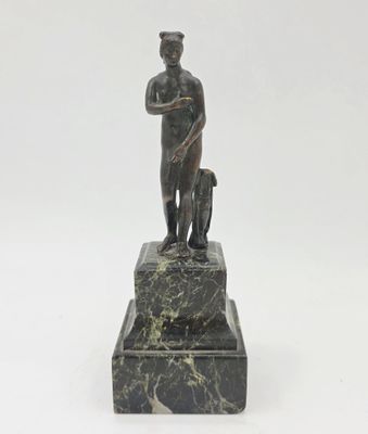 statue d'un homme accompagné d'un chien, posée sur un socle en marbre