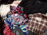 a suitcase full of clothes and ties sitting on the floor