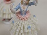 three figurines of a woman in a tutu skirt