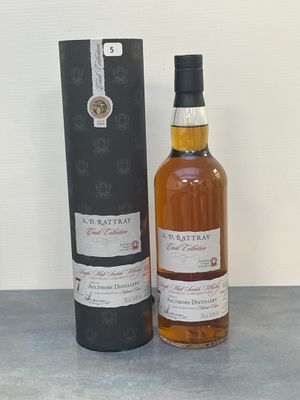l'image d'une bouteille de whisky posée à côté d'une boîte