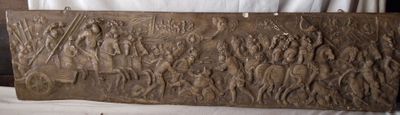 un vieux panneau en bois orné de sculptures, posé sur une table