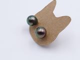 two black pearls on a piece of paper on a white surface