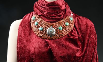 une image représentant une femme vêtue d'une robe rouge et portant un collier