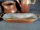 many different types of copper pots and pans on the table