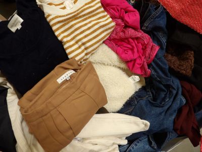 a suitcase full of clothes and a handbag on the floor