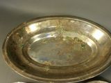 a silver plate with a spoon and spoon rest on a table
