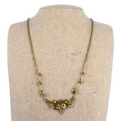 the necklace is made of brass beads and has a bird design on it