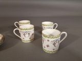three coffee cups with floral designs on them sit next to a plate