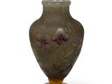 un vase sur lequel sont peintes des fleurs sur fond blanc