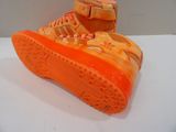 a pair of orange shoes that are on a table