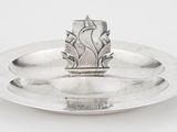 un plat en argent ancien surmonté d'un bougeoir