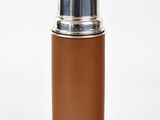 un gros plan d'une bouteille munie d'un bouchon métallique sur fond blanc