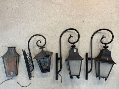 Trois lampadaires à l'ancienne sont accrochés en rangée sur un mur