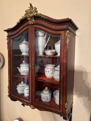 une vitrine remplie de vaisselle en porcelaine