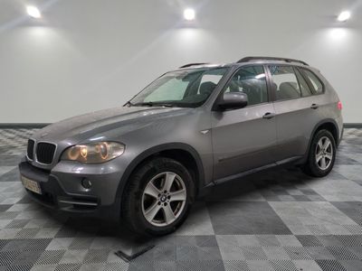 une photo d'un SUV BMW argenté garé dans un garage